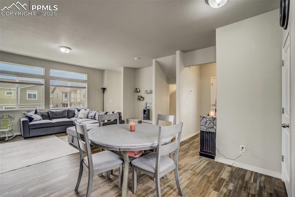 Image 9 of 27: Dining space featuring wood finished floors and a textured ceiling
