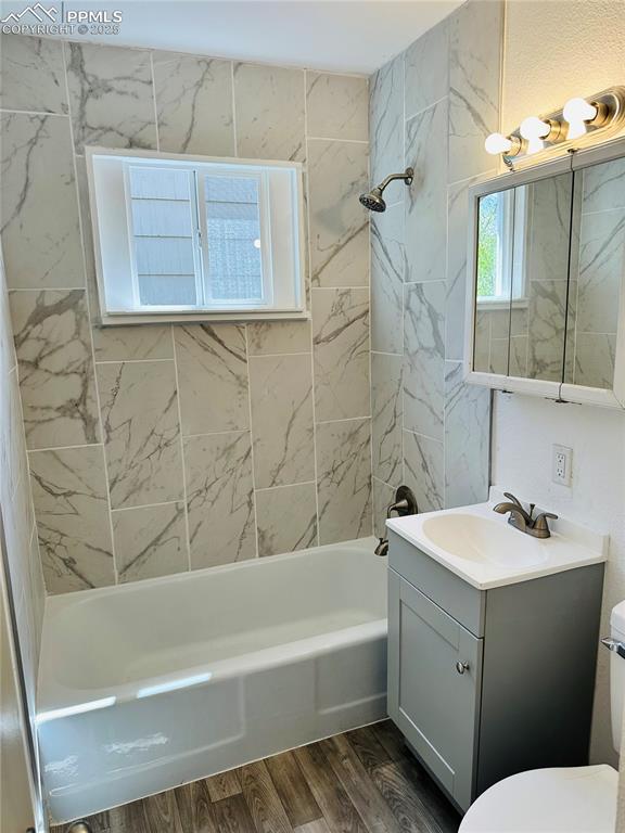 Image 7 of 9: Bathroom with vanity, shower / washtub combination, and wood finished floor
