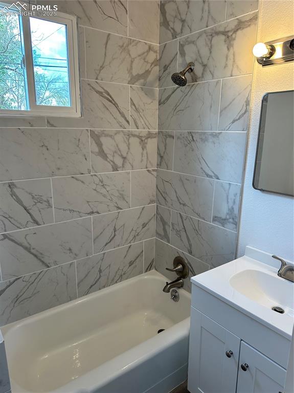 Image 9 of 9: Bathroom with vanity, shower / bathtub combination, and a textured wall