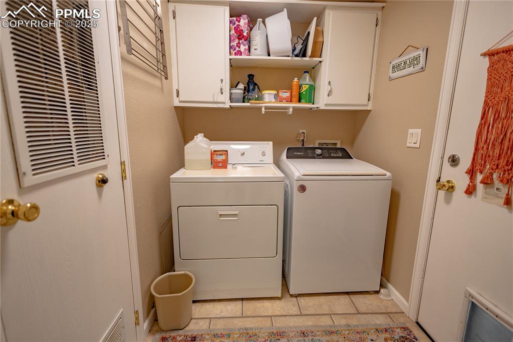 Image 15 of 19: Laundry area with cabinet space, washing machine and dryer, a heating unit,
