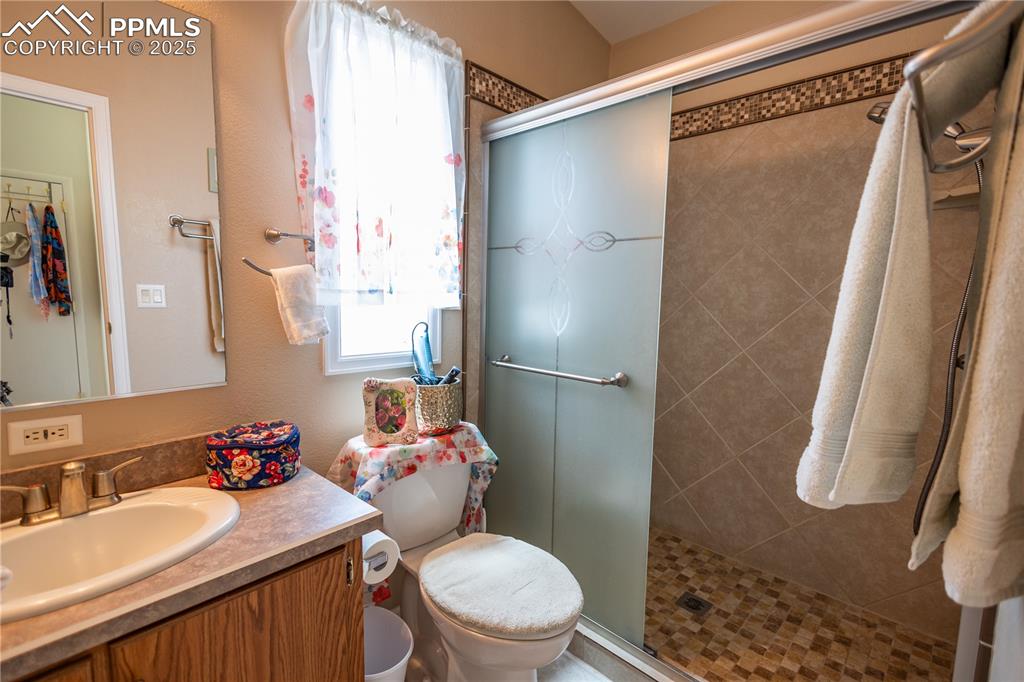 Image 18 of 19: Bathroom featuring plenty of natural light, a stall shower, and vanity