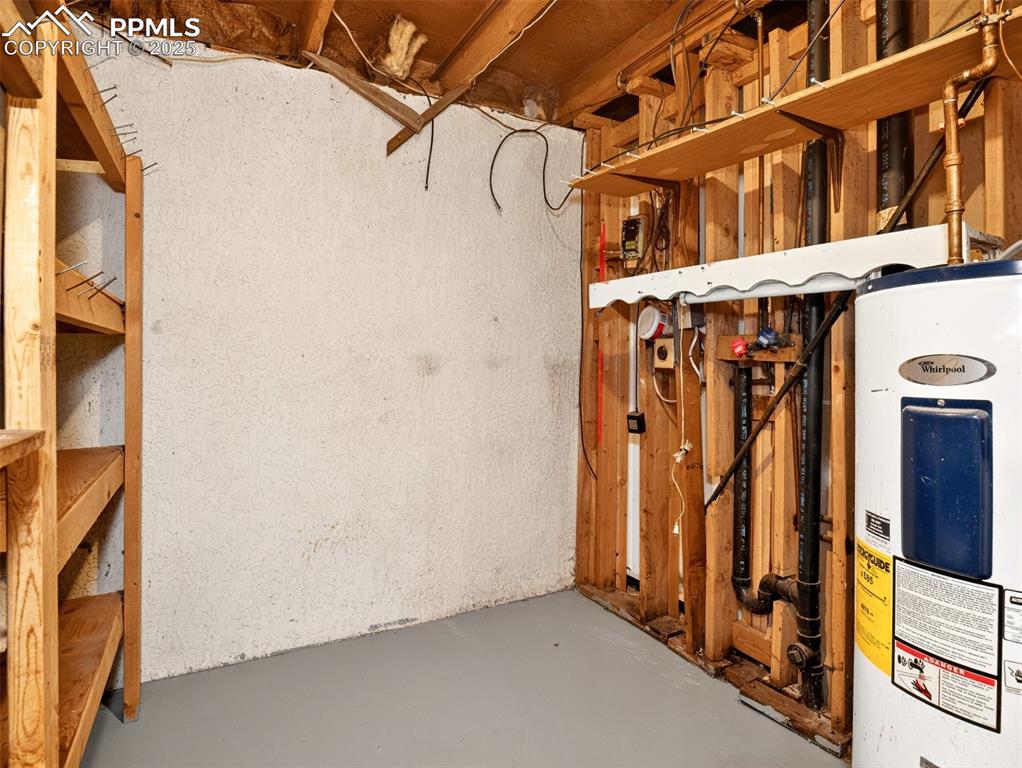 Image 35 of 44: Basement level storage room and laundry with large wood shelves