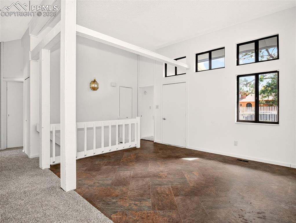 Image 4 of 44: Front entry and dining space with high vaulted ceilings and second story wi