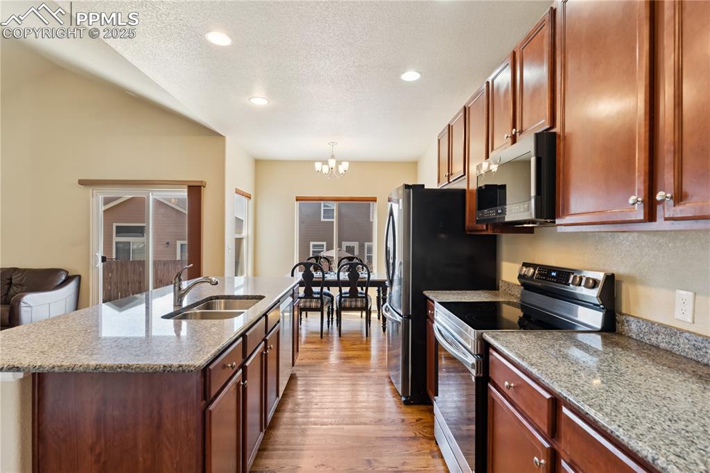 Image 10 of 28: The kitchen is adjacent to the dining nook with lots of windows for natural