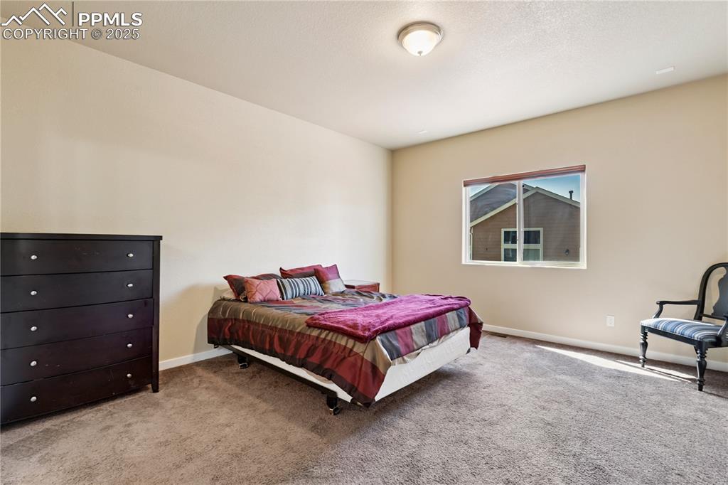 Image 11 of 28: The master bedroom on the main level features the same warm but easy to mat