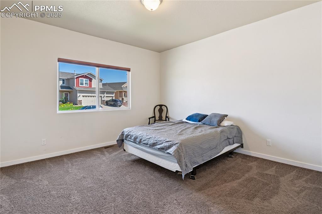 Image 15 of 28: Bedroom #2 of 4 is on the main floor at the front of the home.