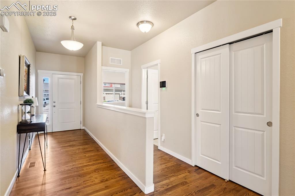 Image 3 of 28: Entryway with lots of solid-oak flooring upgrades, a coat closet on the lef