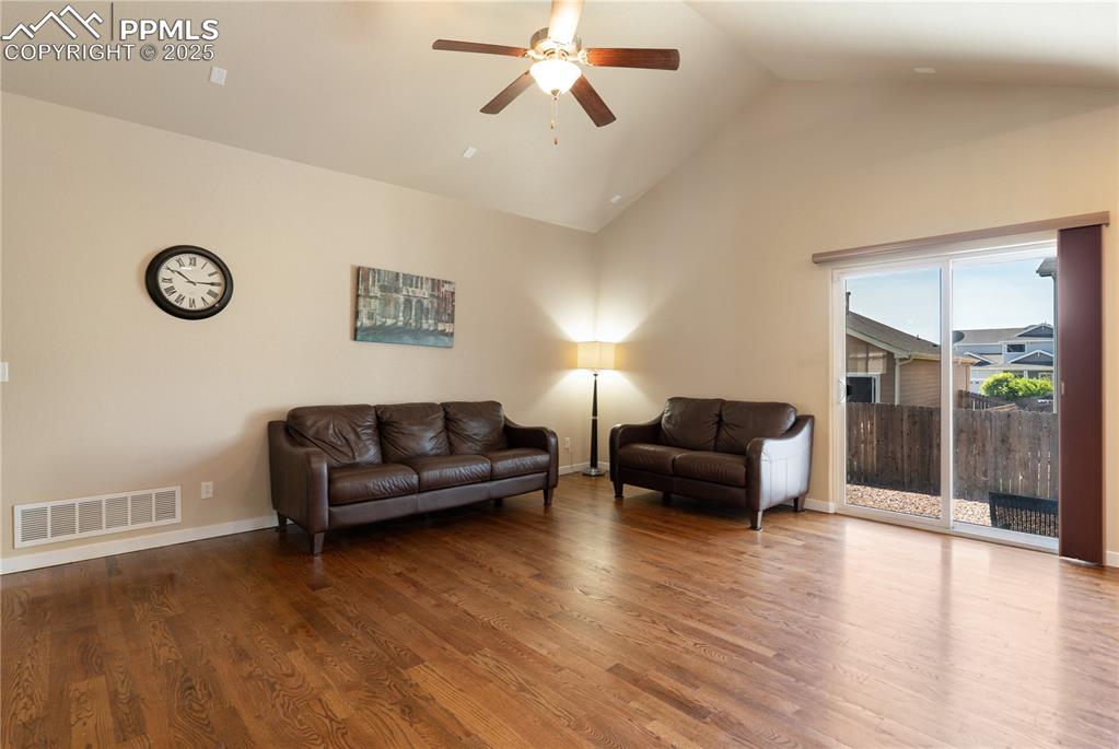 Image 5 of 28: Solid oak floors in the living room and a full-glass door leading to your c