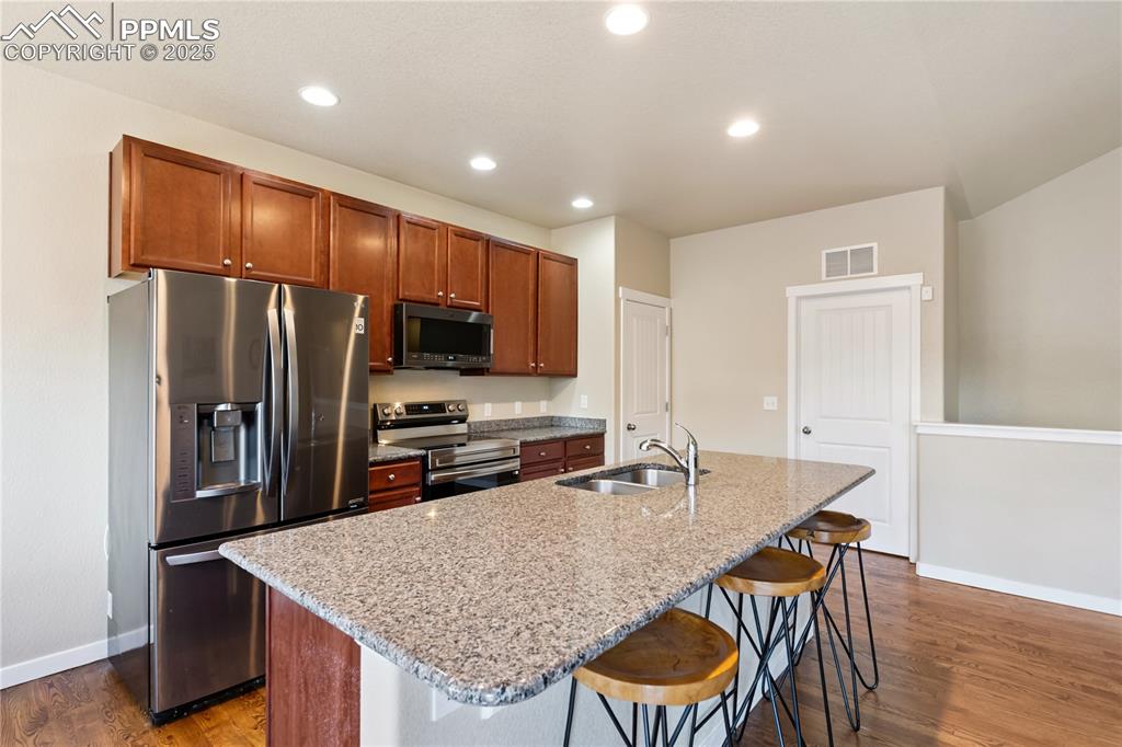 Image 7 of 28: The kitchen has granite counters, a full pantry, and the garage is just thr