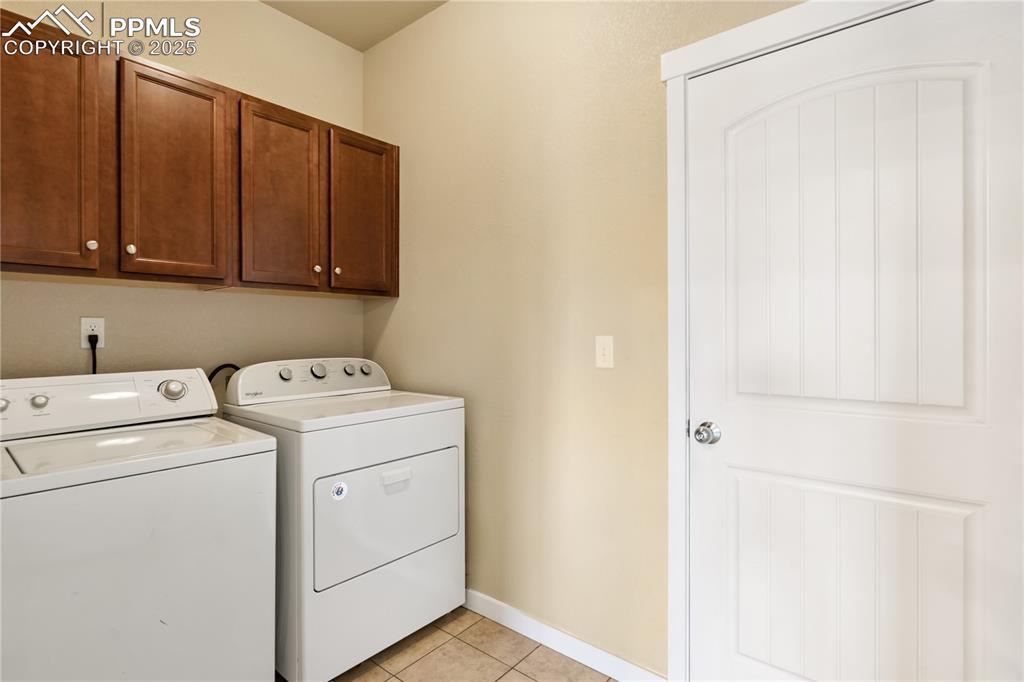 Image 8 of 28: The laundry space is between the kitchen and garage, with durable tile floo