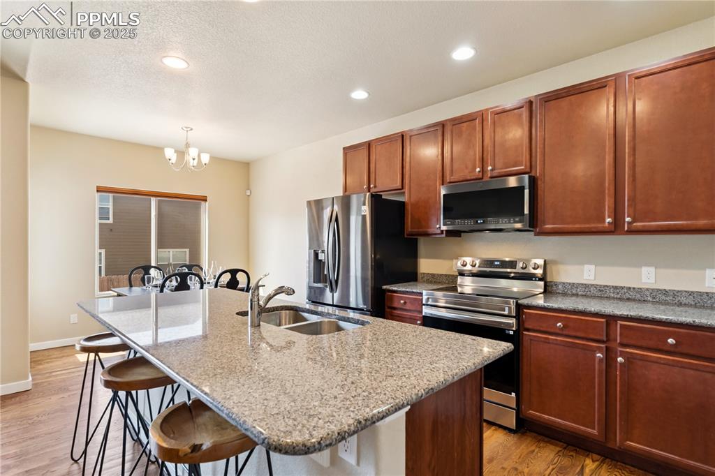 Image 9 of 28: The kitchen is a great space to share while cooking, with a breakfast bar i