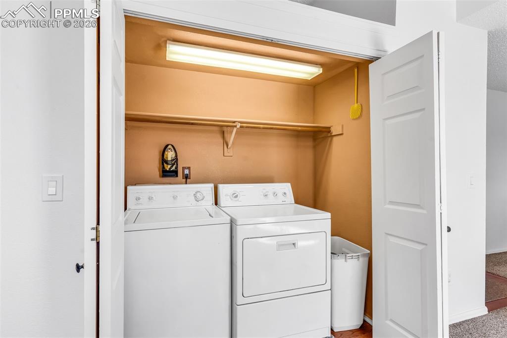 Image 11 of 27: Convenient laundry closet located off the kitchen with built-in shelving an