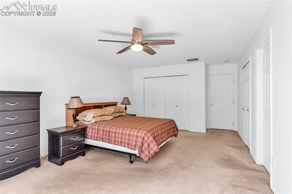 Image 12 of 27: Generous master suite featuring dual closets, bright open space, and a cool