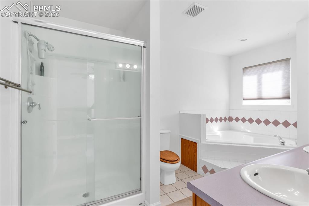 Image 15 of 27: Second angle of en-suite bathroom featuring a walk-in glass shower and jet-