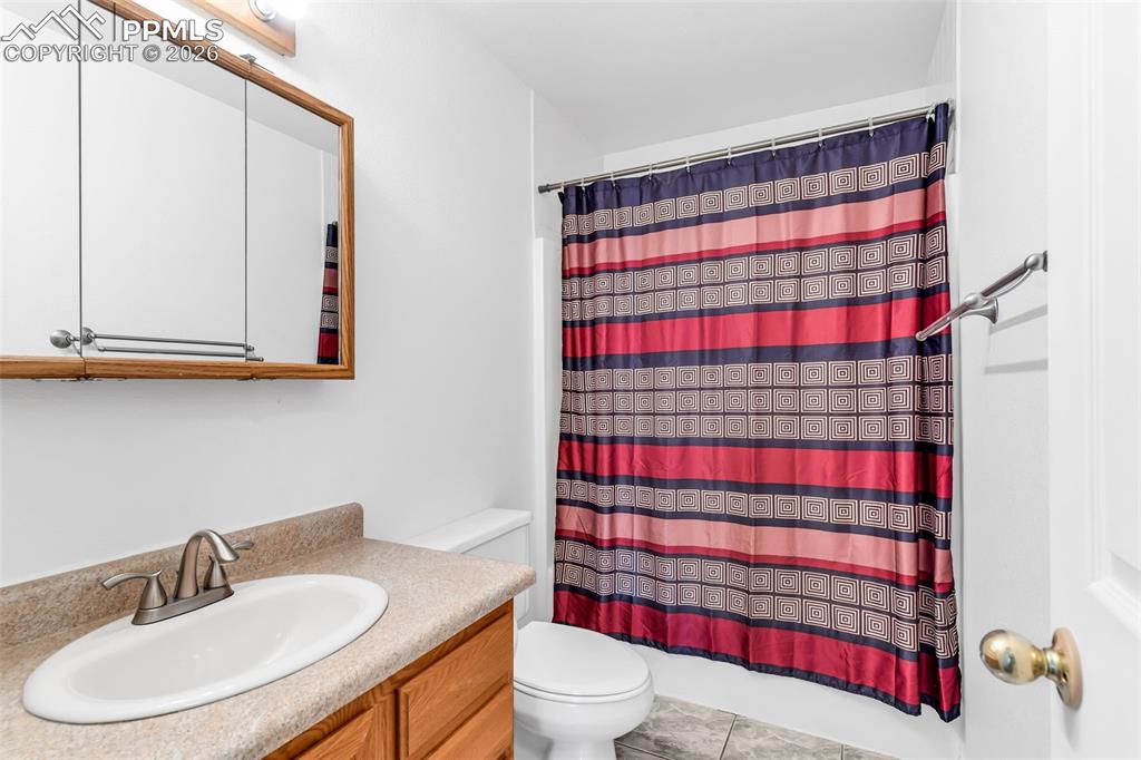 Image 16 of 27: Full main bathroom featuring a tub/shower combo, large vanity mirror, and n