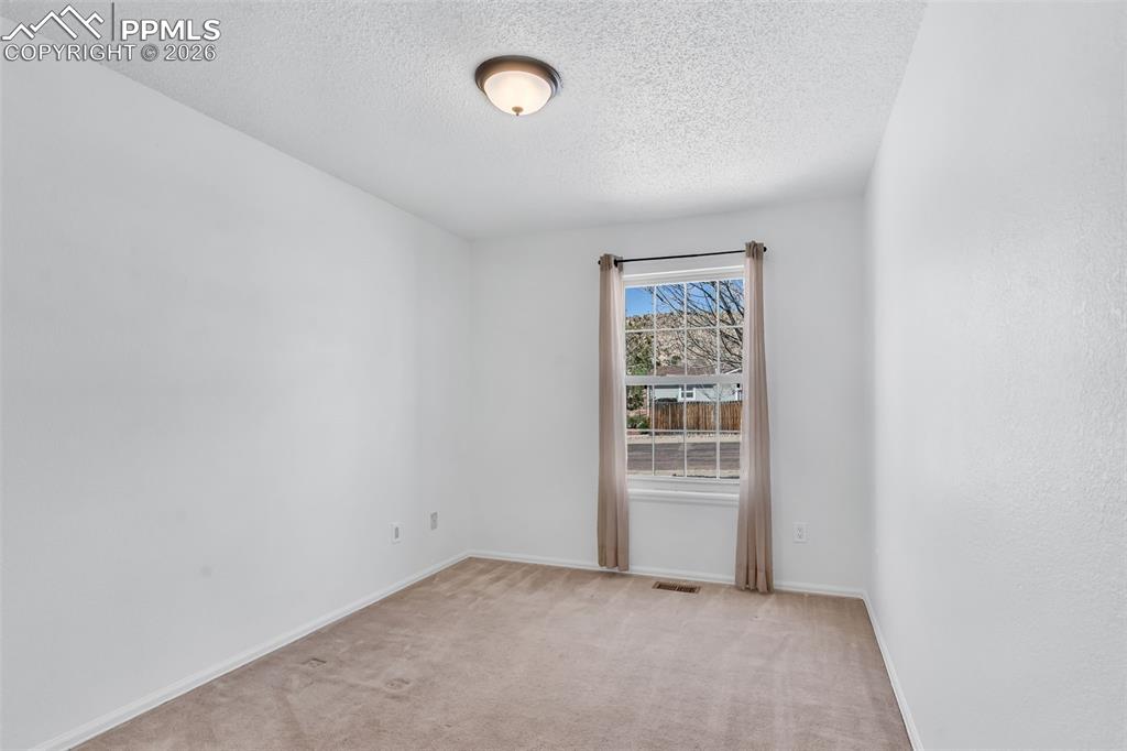 Image 18 of 27: Third bedroom offering a clean, flexible space with ample natural light and