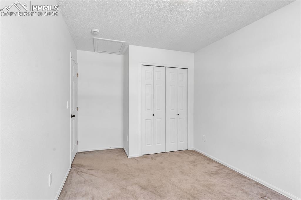 Image 19 of 27: Alternative view of the third bedroom highlighting the double-door closet.