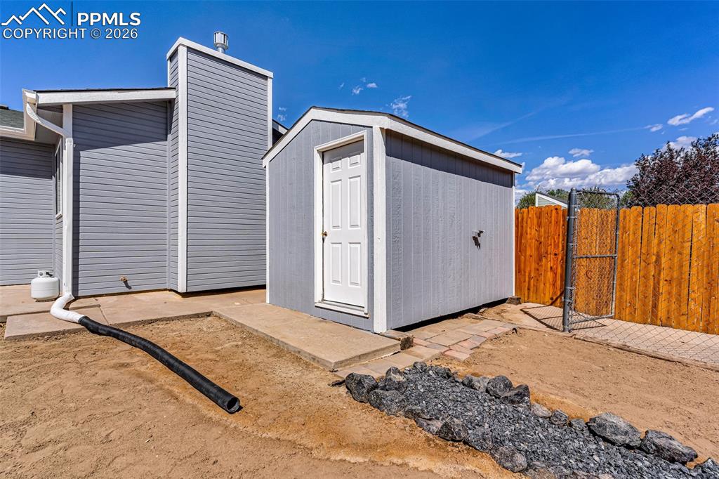 Image 23 of 27: Included storage shed and entrance to dog-run.