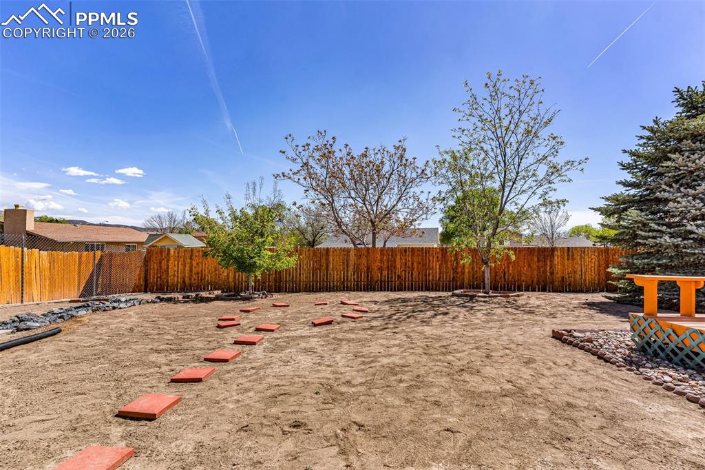 Image 24 of 27: Fully enclosed backyard with secure wood fencing, offering a massive footpr