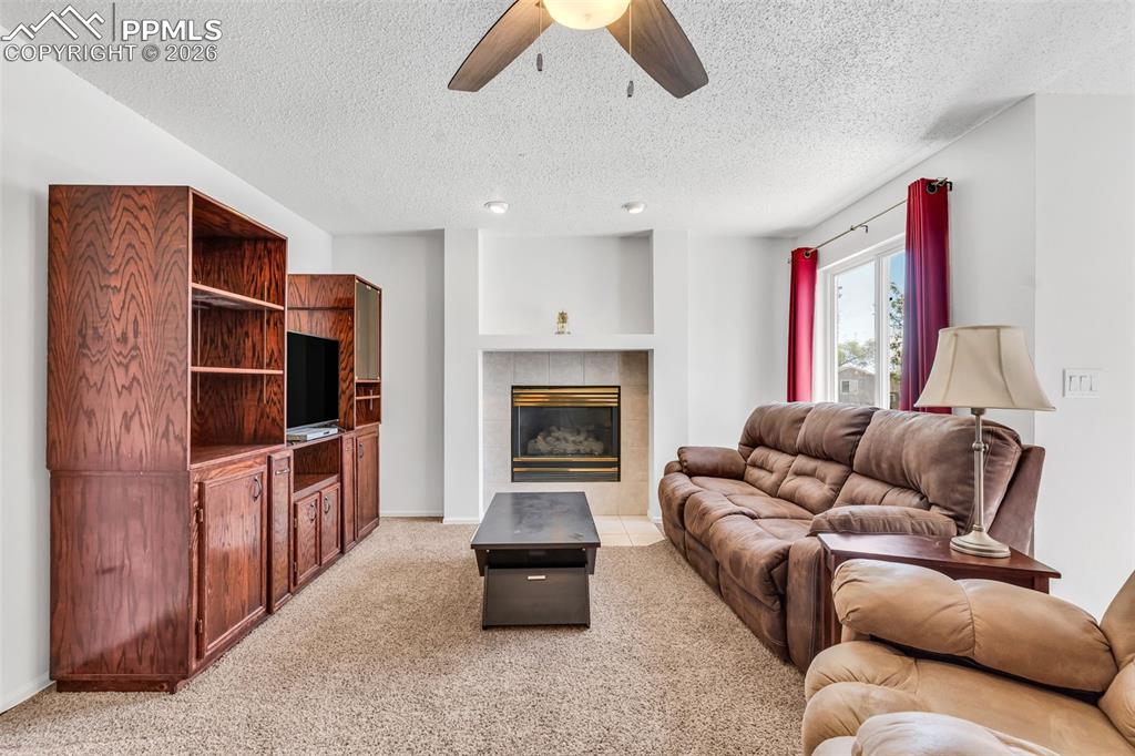 Image 4 of 27: Bright, open living room with fireplace centerpiece and generous space for 