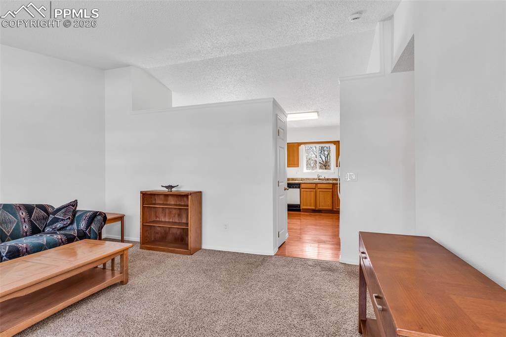 Image 6 of 27: View from the entryway leading into the kitchen and main living space.