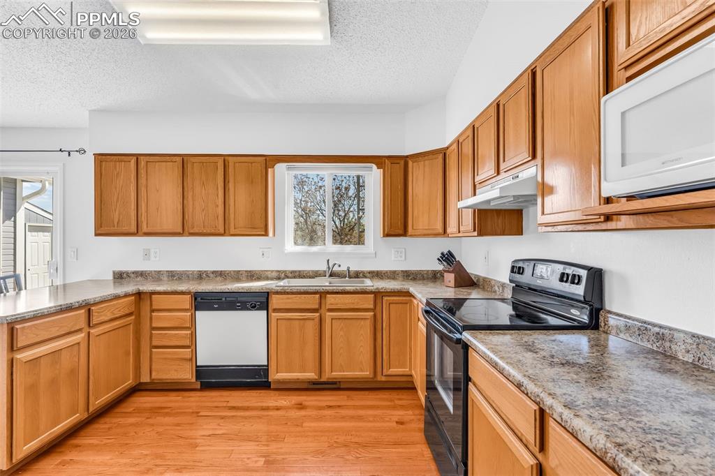 Image 7 of 27: Functional U-shaped kitchen layout with extensive counter space, dishwasher