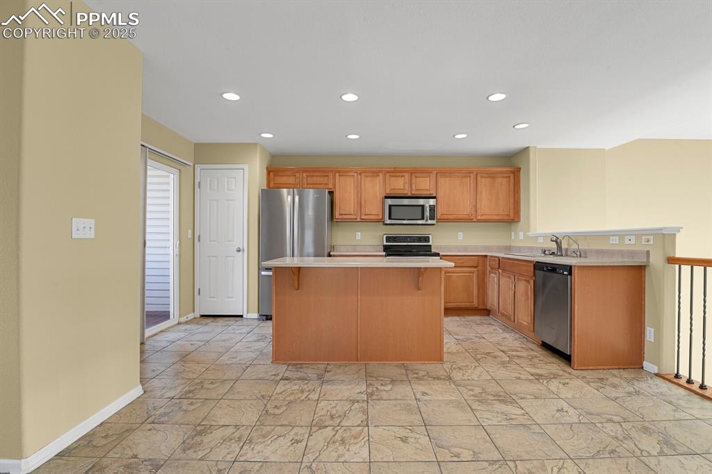 Image 21 of 45: Kitchen featuring light countertops, recessed lighting, stainless steel app