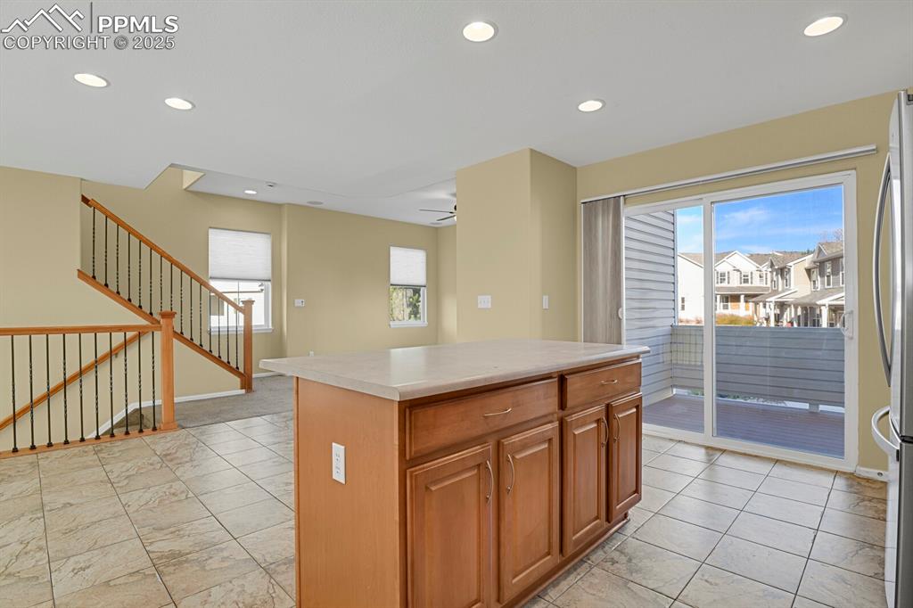Image 22 of 45: Kitchen featuring brown cabinets, recessed lighting, a center island, healt