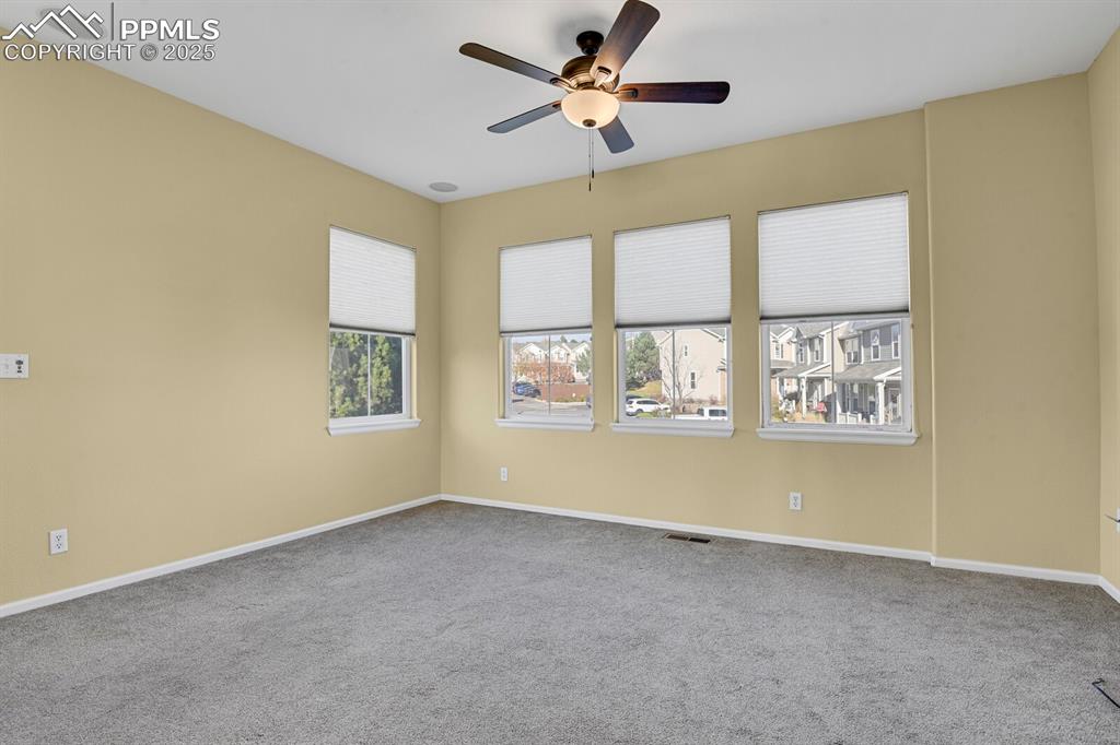 Image 24 of 45: Carpeted empty room featuring baseboards and ceiling fan