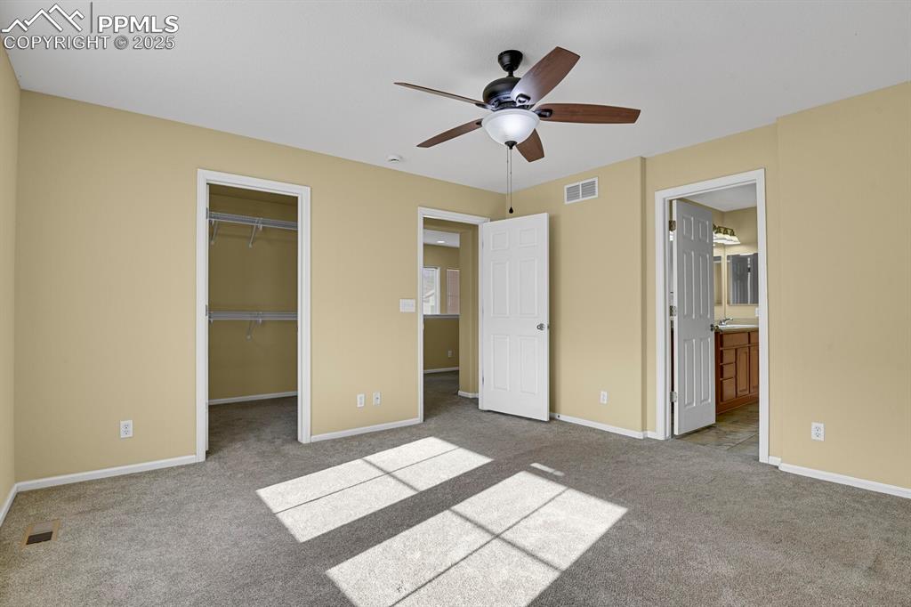 Image 31 of 45: Unfurnished bedroom with light colored carpet, a spacious closet, ensuite b