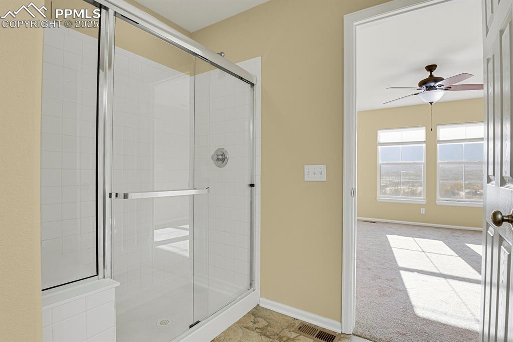 Image 34 of 45: Full bathroom featuring ceiling fan, a stall shower, and light colored carp