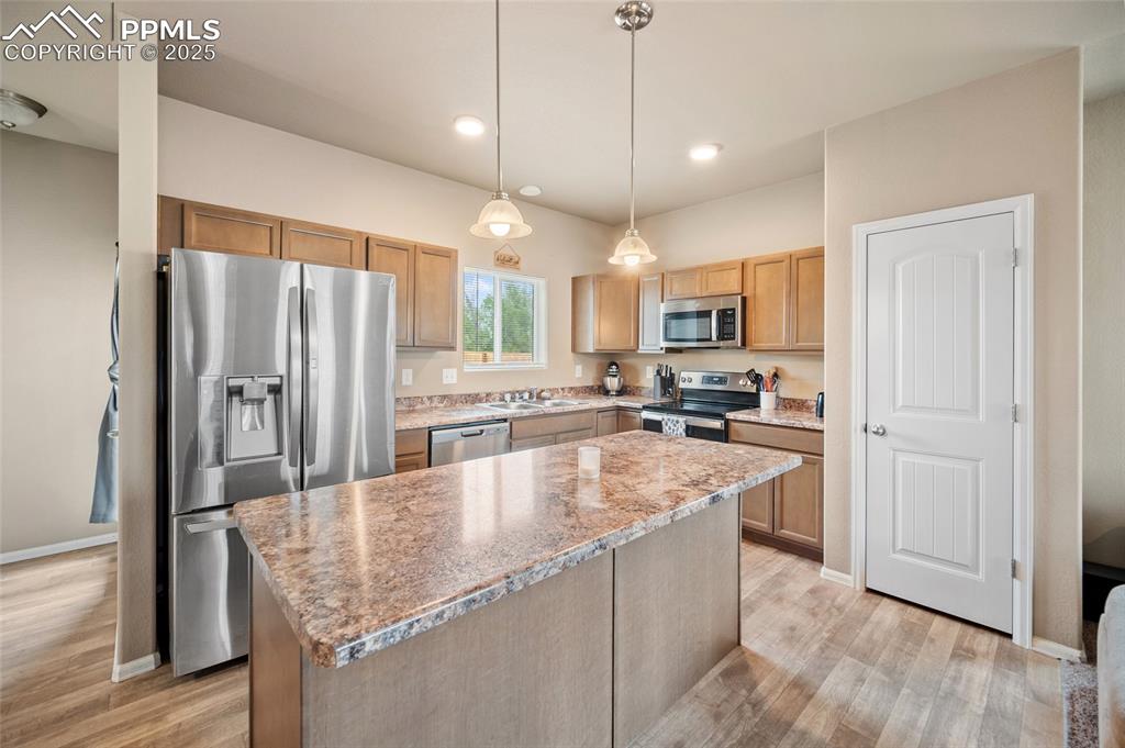 Image 3 of 12: Kitchen with appliances with stainless steel finishes, light wood finished
