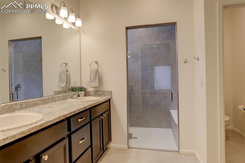 Image 19 of 29: Dual vanity, zero entry shower and large walk-in closet
