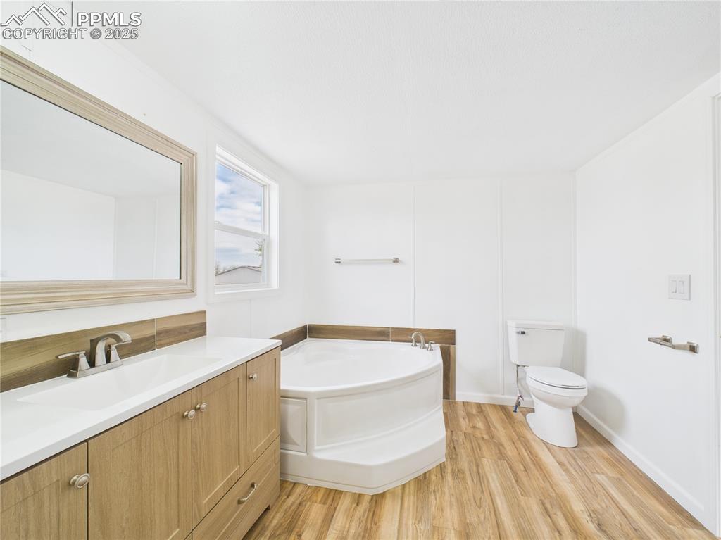 Image 18 of 34: Bathroom with toilet vanity, and a garden tub