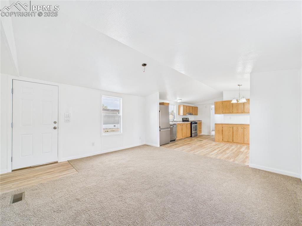 Image 4 of 34: Unfurnished living room featuring visible vents, light colored carpet, base