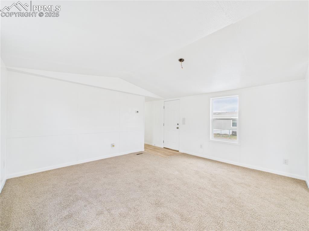 Image 5 of 34: Unfurnished room with carpet floors, baseboards, and vaulted ceiling