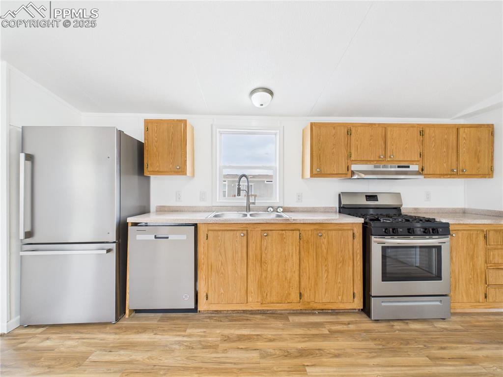 Image 7 of 34: Kitchen with a sink, light countertops, appliances with stainless steel fin