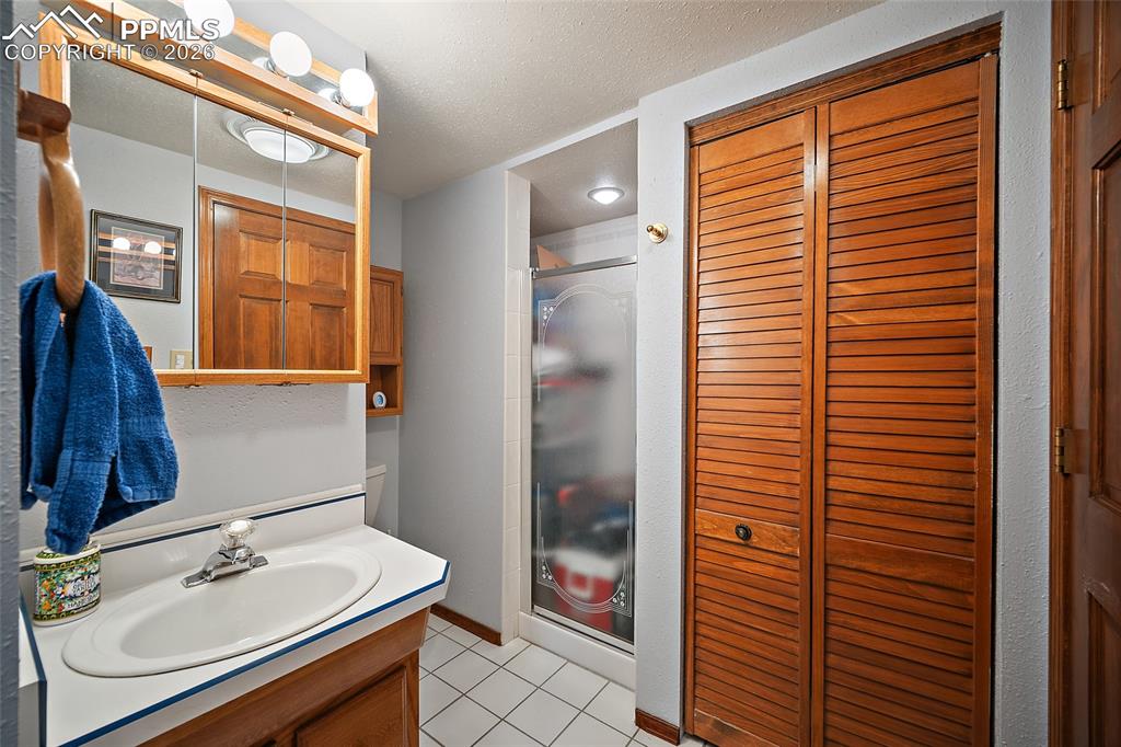 Image 22 of 49: Adjoining bath for lower-level bedroom.