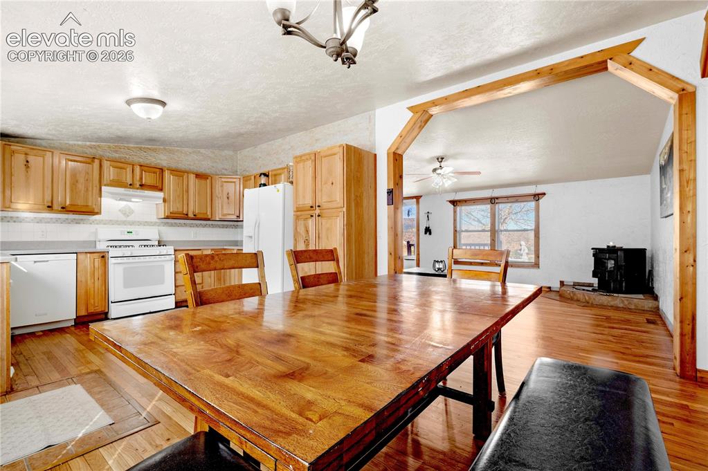 Image 10 of 48: Unfurnished dining area with a textured ceiling, ceiling fan, light wood-ty