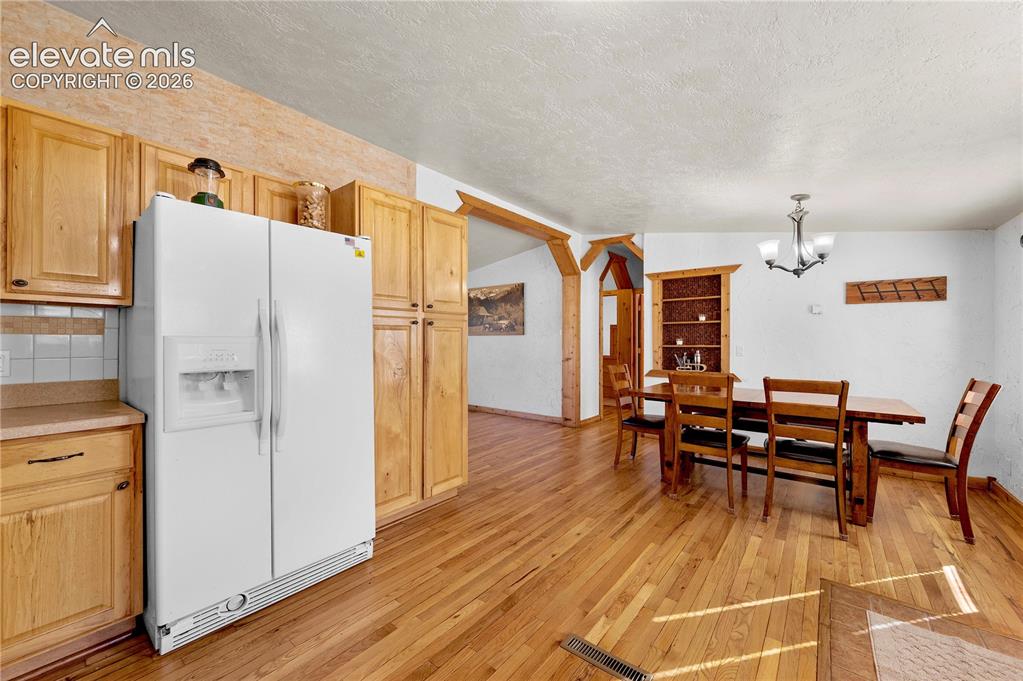 Image 14 of 48: Dining space featuring light hardwood / wood-style flooring, a textured cei