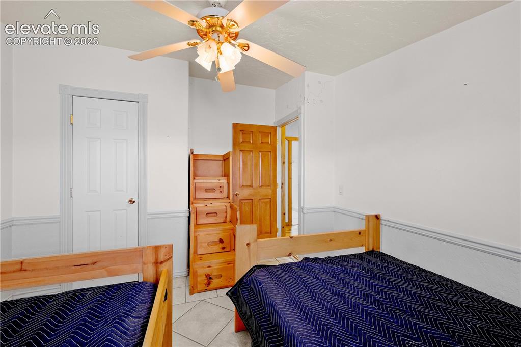 Image 16 of 48: Tiled bedroom featuring ceiling fan
