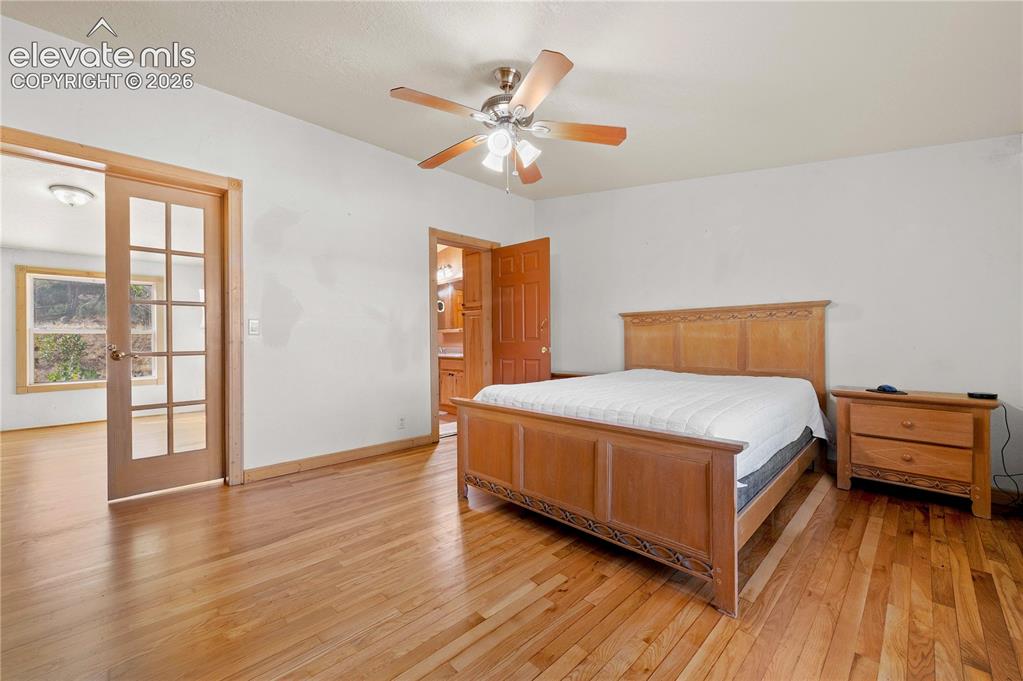 Image 23 of 48: Bedroom featuring light hardwood / wood-style floors, french doors, ensuite