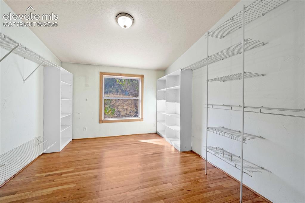 Image 25 of 48: Spacious closet with lofted ceiling and wood-type flooring