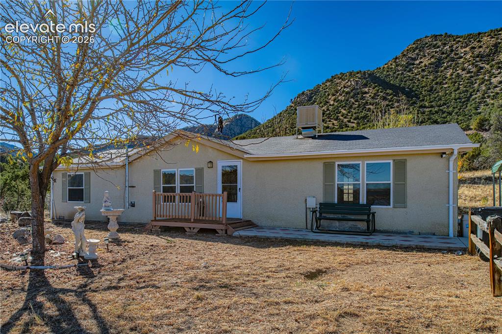 Image 3 of 48: Rear view of property featuring a deck with mountain view, a patio, and cen