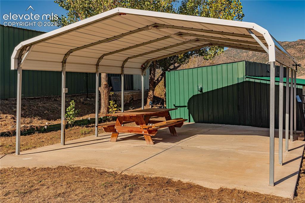 Image 37 of 48: View of parking with a carport