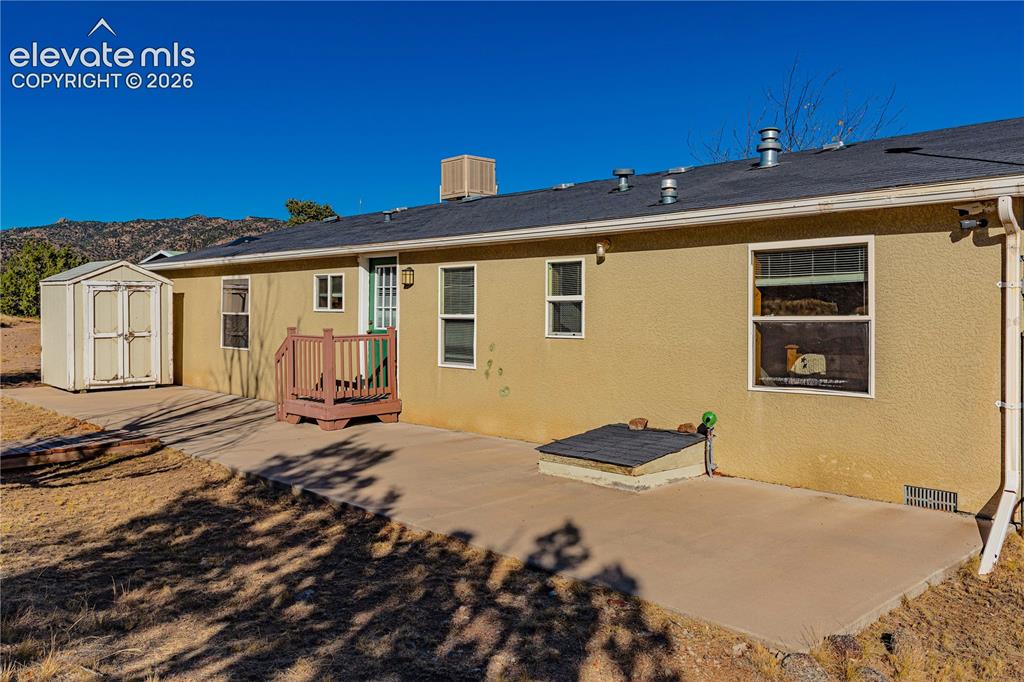 Image 4 of 48: Rear view of house featuring a patio area, a mountain view, and a storage u