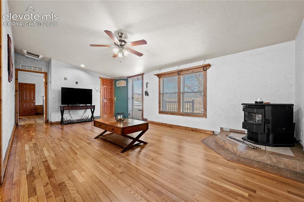 Image 7 of 48: Living room with light hardwood / wood-style flooring, a textured ceiling, 