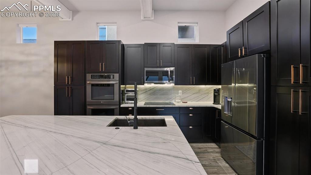 Image 16 of 50: Appliances include a cooktop, double ovens, dishwasher, microwave, and Fren