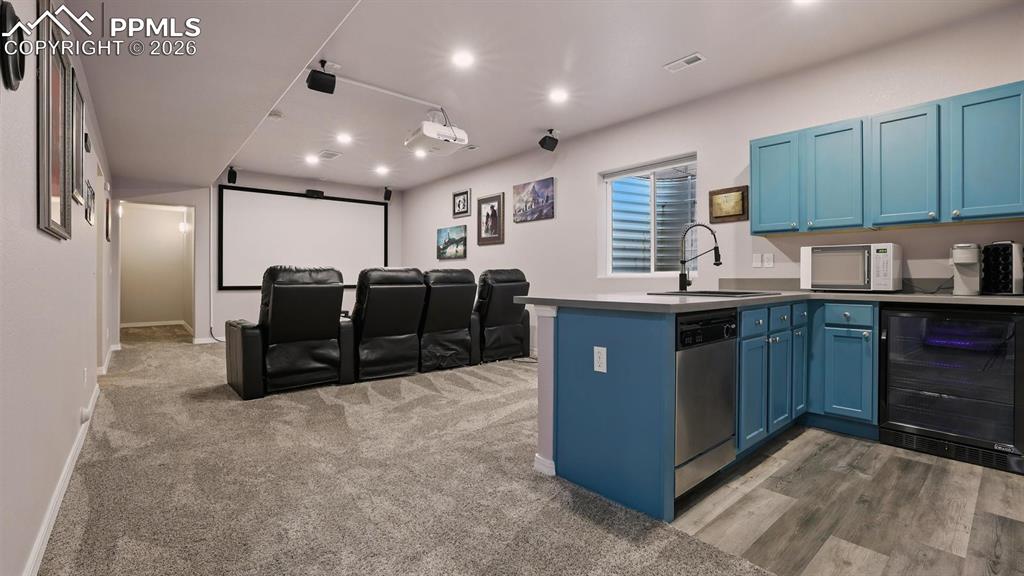 Image 37 of 50: Basement Theatre Room with seating, projector and equipment.