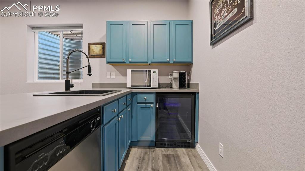 Image 38 of 50: Basement Wet Bar with dishwasher and beverage refrigerator.